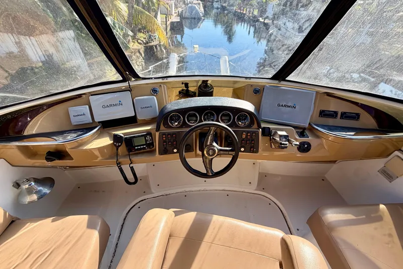Slide: The Image of 2002 Carver 444 Cockpit Motor Yacht helm with Garmin navigation systems and leather seating. - 10