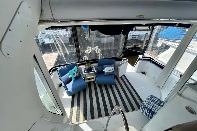 Slide: The Image of 2002 Carver 444 Cockpit Motor Yacht interior with blue chairs and striped rug. - 12
