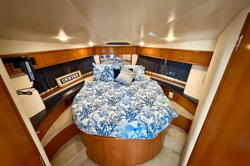 Slide: The Image of Luxurious 2002 Carver 444 Cockpit Motor Yacht bedroom with elegant bedding and wood cabinetry. - 16