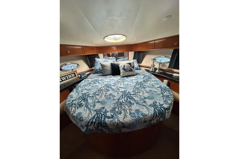 Slide: The Image of 2002 Carver 444 Cockpit Motor Yacht bedroom with nautical-themed bedding and decor. - 17