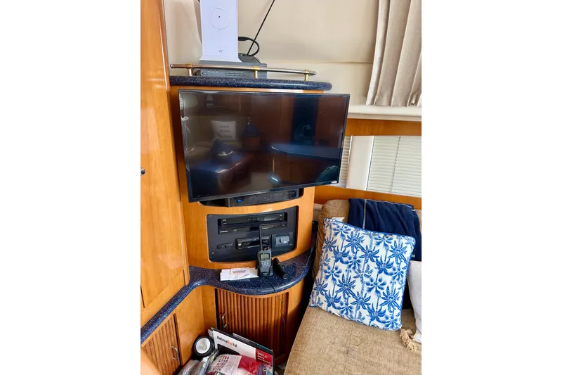 Slide: The Image of Interior of 2002 Carver 444 Cockpit Motor Yacht with TV and blue-patterned pillow. - 6