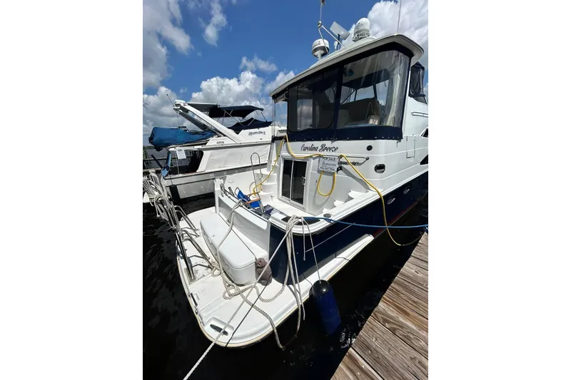 Slide: The Image of 2002 Carver 444 Cockpit Motor Yacht docked, featuring spacious deck and sleek design. - 7