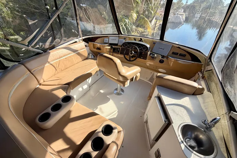 Slide: The Image of Interior of 2002 Carver 444 Cockpit Motor Yacht with helm, seating, and sink. - 9