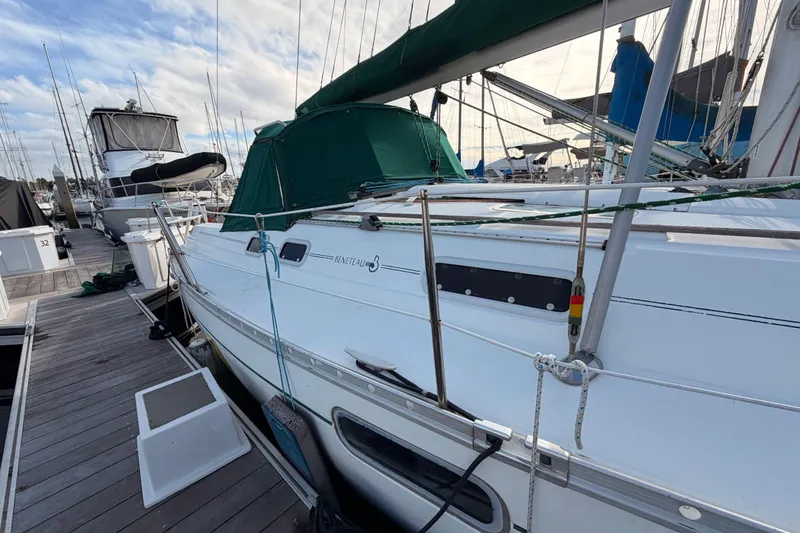 Slide: The Image of 1995 Beneteau Oceanis 351 sailboat docked at marina, featuring green canopy. - 13