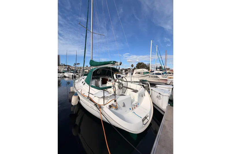 Slide: The Image of 1995 Beneteau Oceanis 351 sailboat docked in a marina under a clear blue sky. - 14