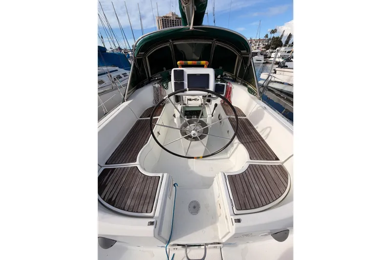 Slide: The Image of 1995 Beneteau Oceanis 351 sailboat cockpit with wooden seating and steering wheel. - 16