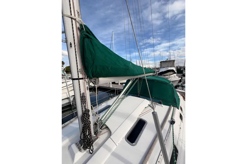 Slide: The Image of 1995 Beneteau Oceanis 351 sailboat with green sail cover, docked at marina. - 26