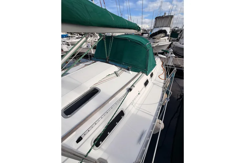 Slide: The Image of 1995 Beneteau Oceanis 351 sailboat docked, featuring green canopy and sleek white deck. - 28