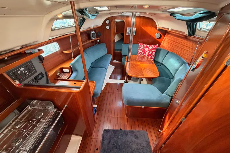 Slide: The Image of Interior of 1995 Beneteau Oceanis 351 sailboat with wood finish and blue seating. - 33