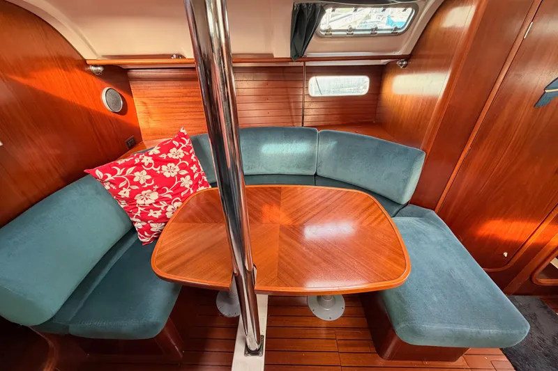 Slide: The Image of Interior of 1995 Beneteau Oceanis 351 sailboat with cozy seating and wooden table. - 50