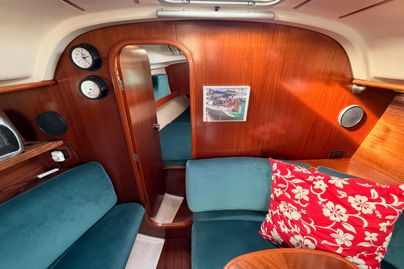 Slide: The Image of Interior of 1995 Beneteau Oceanis 351 sailboat with wood paneling and teal seating. - 52