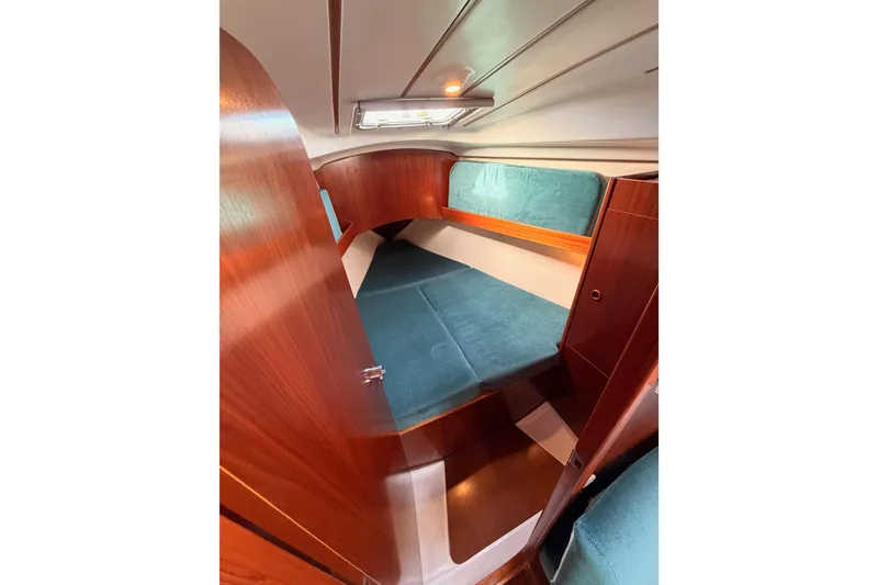 Slide: The Image of Cozy cabin interior of 1995 Beneteau Oceanis 351 sailboat with teal cushions and wood finish. - 53