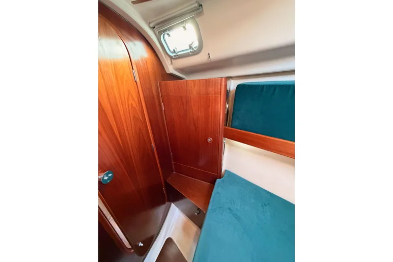 Slide: The Image of Interior cabin of 1995 Beneteau Oceanis 351 sailboat with wooden finish and teal upholstery. - 56