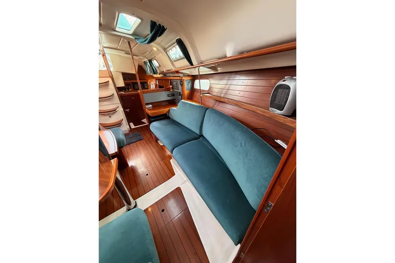 Slide: The Image of Interior of 1995 Beneteau Oceanis 351 sailboat with blue seating and wooden finishes. - 57