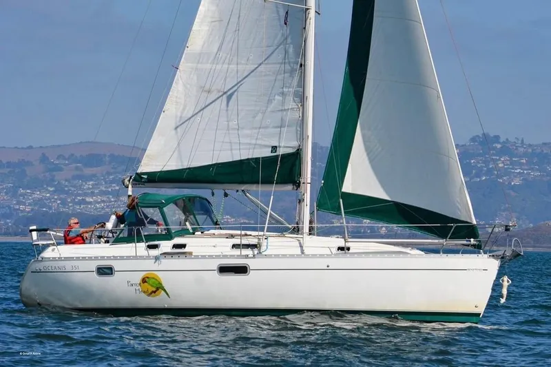 Slide: The Image of 1995 Beneteau Oceanis 351 sailboat on water, green sails, scenic background. - 71