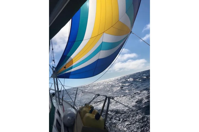 Slide: The Image of Sailing on a 1995 Beneteau Oceanis 351 with colorful spinnaker over open sea. - 76