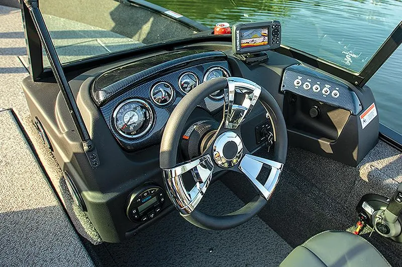 Slide: The Image of 2026 Lowe Fish & Ski 1700 boat with outboard motor, parked outside a marine store. - 1