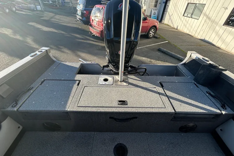 Slide: The Image of 2026 Lowe Fish & Ski 1700 boat interior with motor, parked outdoors. - 12