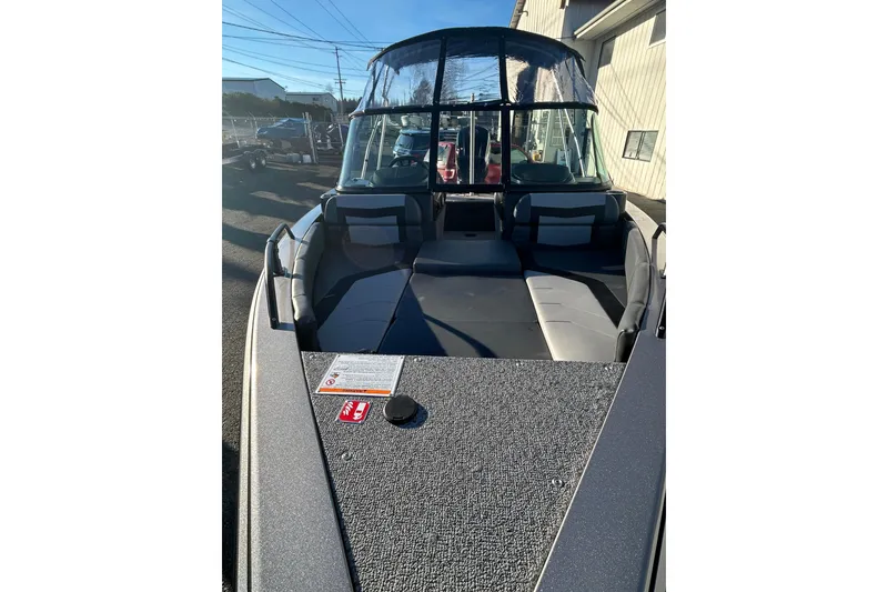 Slide: The Image of 2026 Lowe Fish & Ski 1700 boat with spacious seating and canopy, parked outdoors. - 15