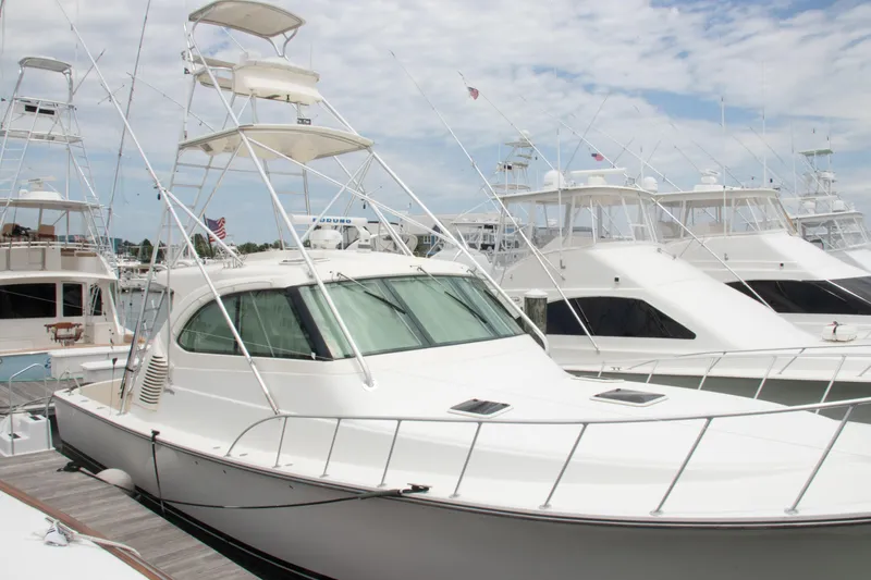 Slide: The Image of 2016 Henriques 42 Express Hardtop yacht docked at marina under cloudy sky. - 11