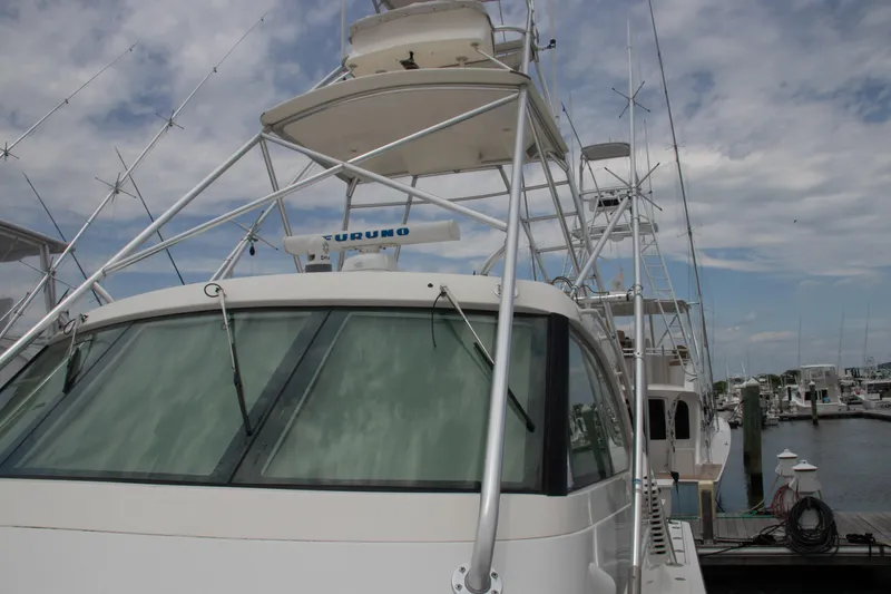 Slide: The Image of 2016 Henriques 42 Express Hardtop boat docked, featuring a hardtop and fishing equipment. - 16