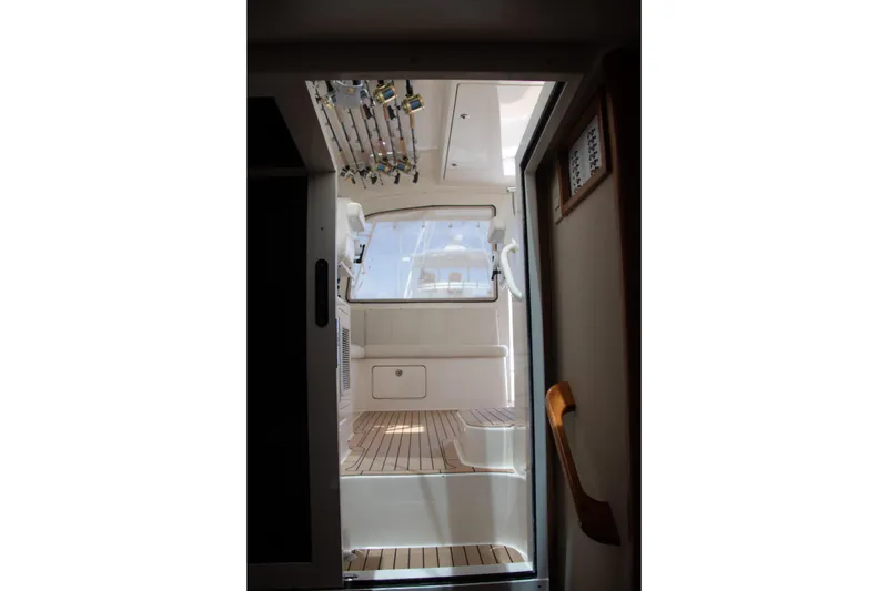 Slide: The Image of Interior view of 2016 Henriques 42 Express Hardtop boat with fishing rods and wooden flooring. - 19