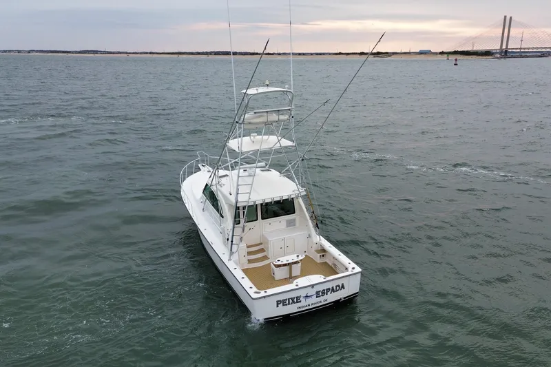 Slide: The Image of 2016 Henriques 42 Express Hardtop boat on open water near a bridge. - 7