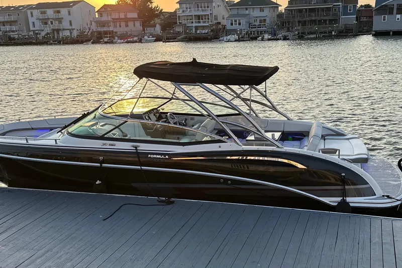 Slide: The Image of 2019 Formula 310 FX Bowrider docked at sunset, waterfront homes in background. - 4
