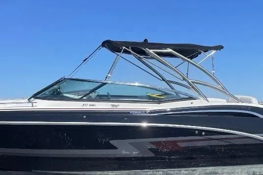 Slide: The Image of 2019 Formula 310 FX Bowrider boat with sleek black design and canopy on open water. - 5