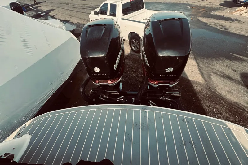 Slide: The Image of 2019 Formula 310 FX Bowrider with dual Mercury outboard engines, parked near a white truck. - 9