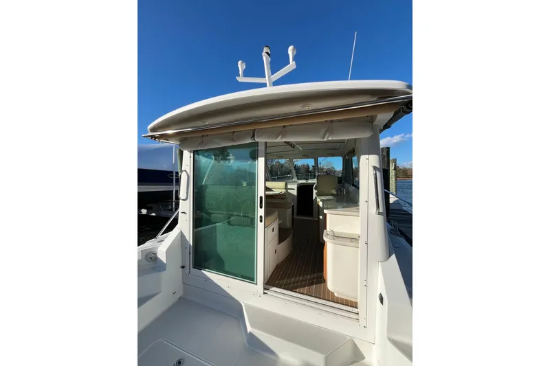 Slide: The Image of 2010 Back Cove 33 Express Hardtop boat with open cabin and clear blue sky. - 10