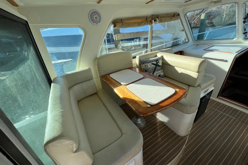 Slide: The Image of 2010 Back Cove 33 Express Hardtop interior with beige seating and wooden table. - 12