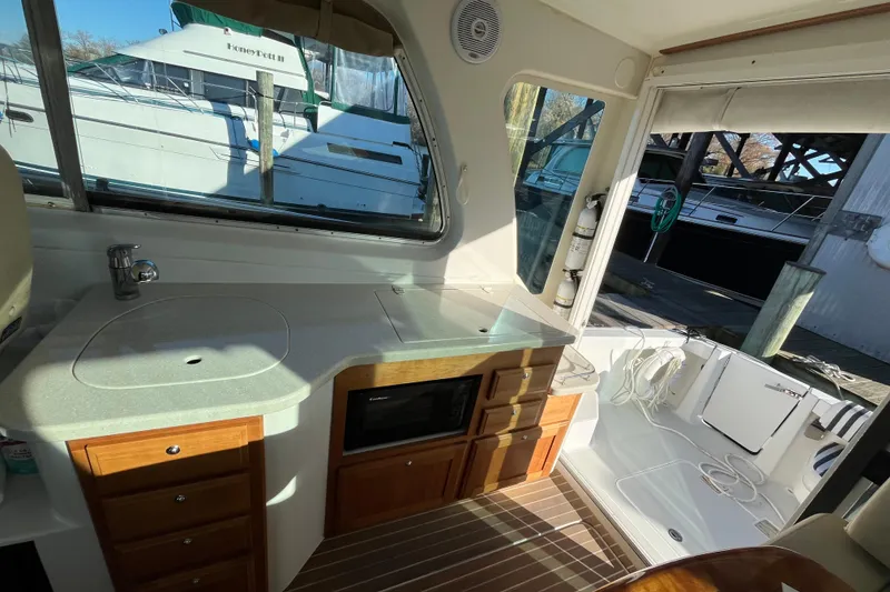 Slide: The Image of 2010 Back Cove 33 Express Hardtop interior with kitchenette and dock view. - 13