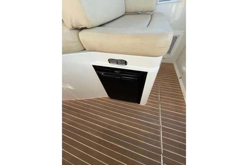 Slide: The Image of 2010 Back Cove 33 Express Hardtop interior with cushioned seating and wooden flooring. - 15
