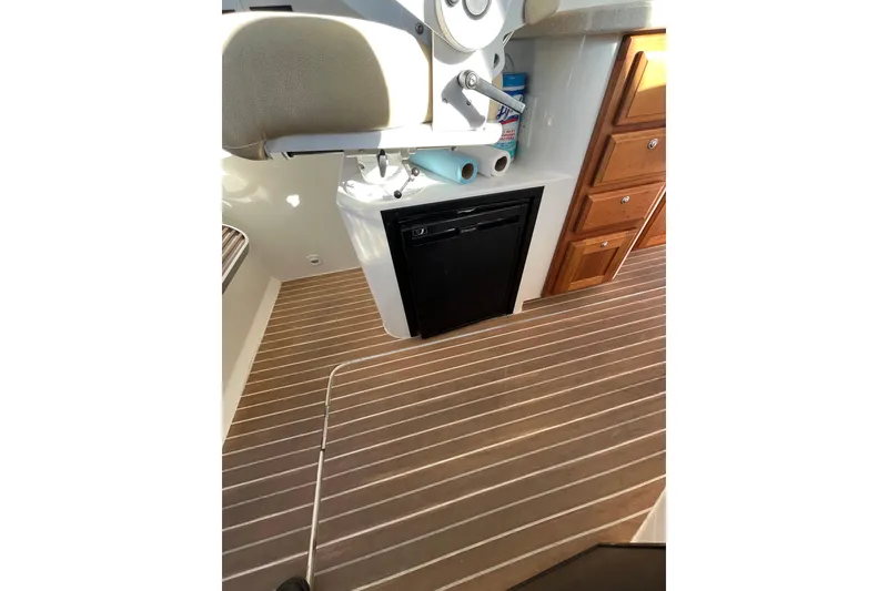 Slide: The Image of 2010 Back Cove 33 Express Hardtop interior with wood flooring and compact kitchen amenities. - 16