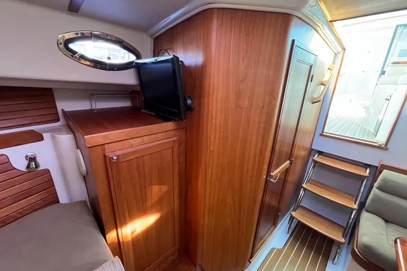 Slide: The Image of 2010 Back Cove 33 Express Hardtop interior with wood cabinetry and compact TV. - 18