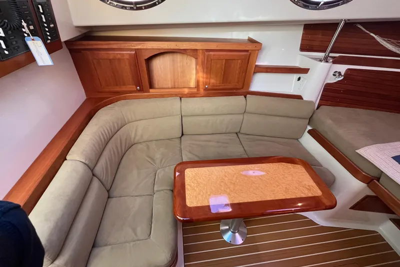 Slide: The Image of 2010 Back Cove 33 Express Hardtop interior with beige seating and wooden table. - 22