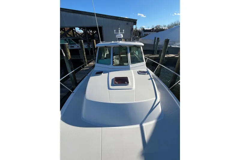 Slide: The Image of 2010 Back Cove 33 Express Hardtop boat docked at marina under clear blue sky. - 4