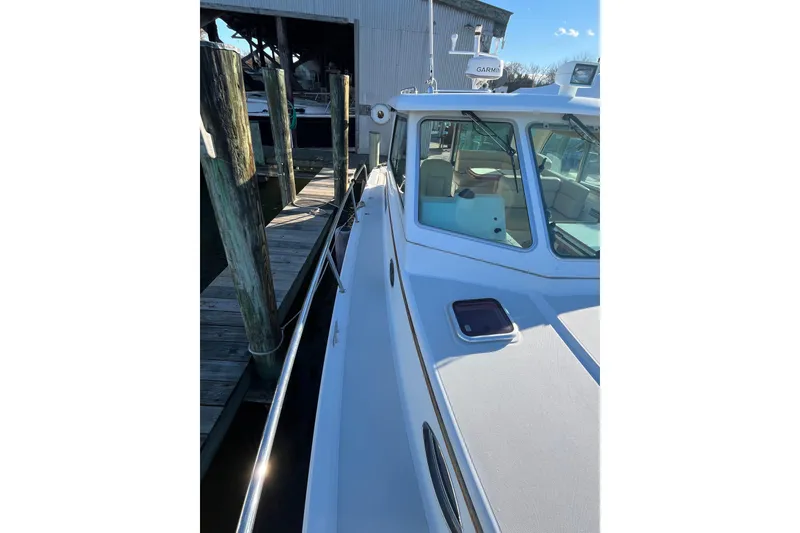 Slide: The Image of 2010 Back Cove 33 Express Hardtop docked, showcasing sleek design and spacious deck. - 5