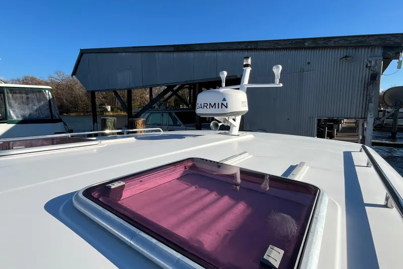 Slide: The Image of 2010 Back Cove 33 Express Hardtop with Garmin radar, docked near a boathouse. - 7