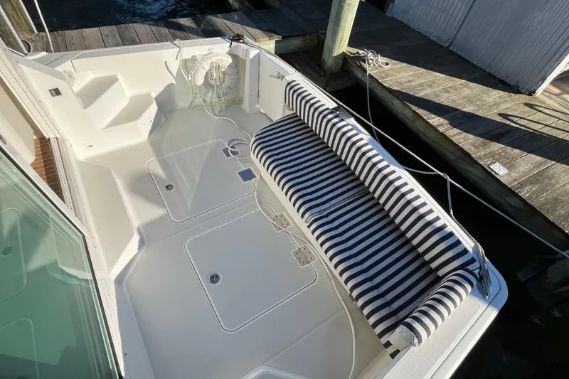 Slide: The Image of 2010 Back Cove 33 Express Hardtop boat with striped seating and dock view. - 8