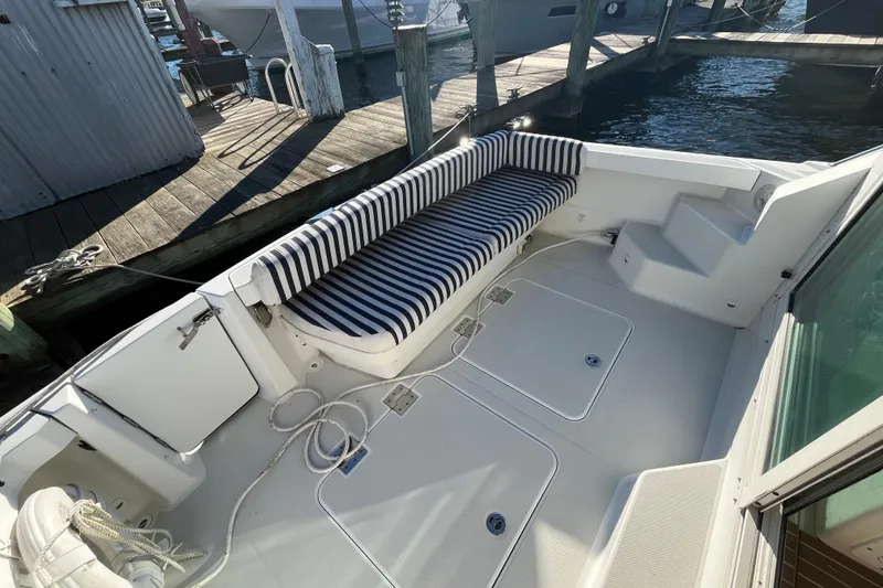 Slide: The Image of 2010 Back Cove 33 Express Hardtop boat with striped seating at dock. - 9