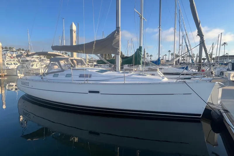 The Image of 2005 Beneteau 323 sailboat docked in a marina, reflecting on calm water. - 0