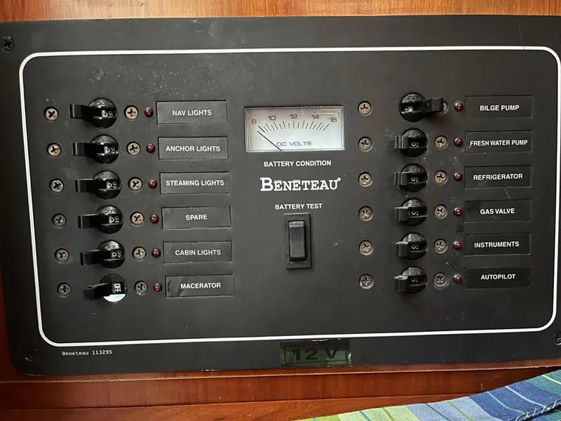 Slide: The Image of Electrical panel of a 2005 Beneteau 323 sailboat, featuring various switches and battery condition meter. - 22