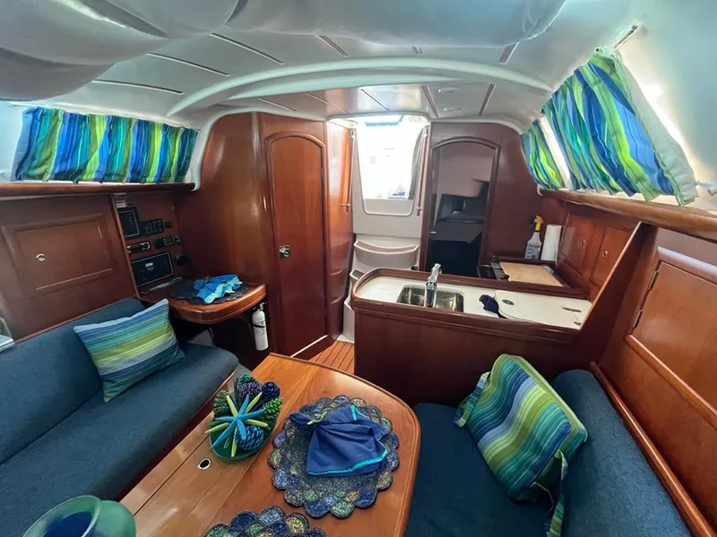 Slide: The Image of Interior of a 2005 Beneteau 323 sailboat with colorful decor and wooden finishes. - 30