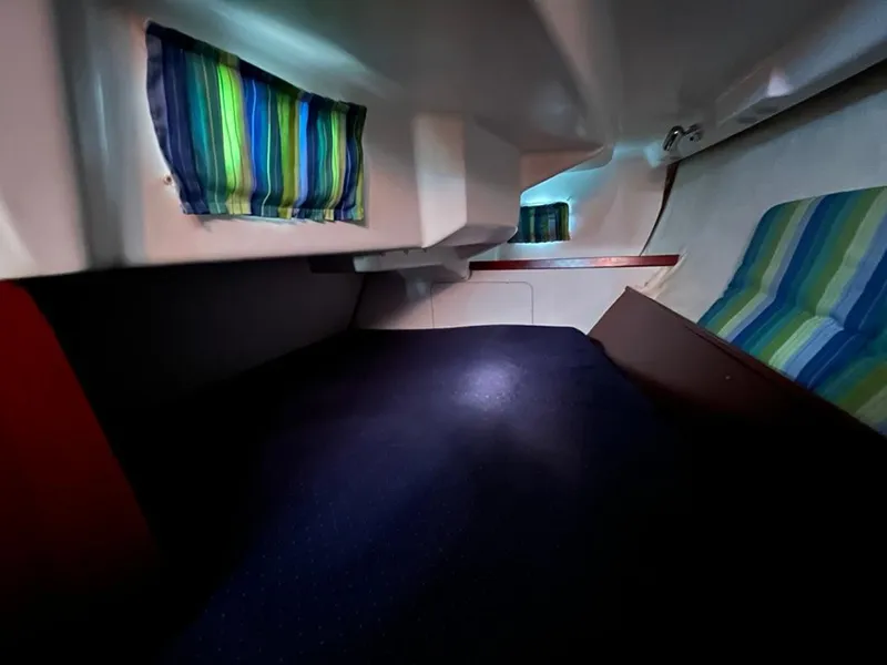 Slide: The Image of Interior cabin of 2005 Beneteau 323 sailboat with striped curtains and seating. - 34