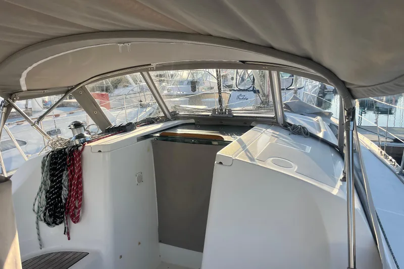 Slide: The Image of 2005 Beneteau 323 sailboat cockpit with ropes and canopy, docked at marina. - 43