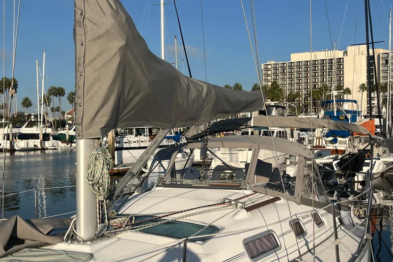 Slide: The Image of 2005 Beneteau 323 sailboat docked in marina, sunny day, palm trees in background. - 45