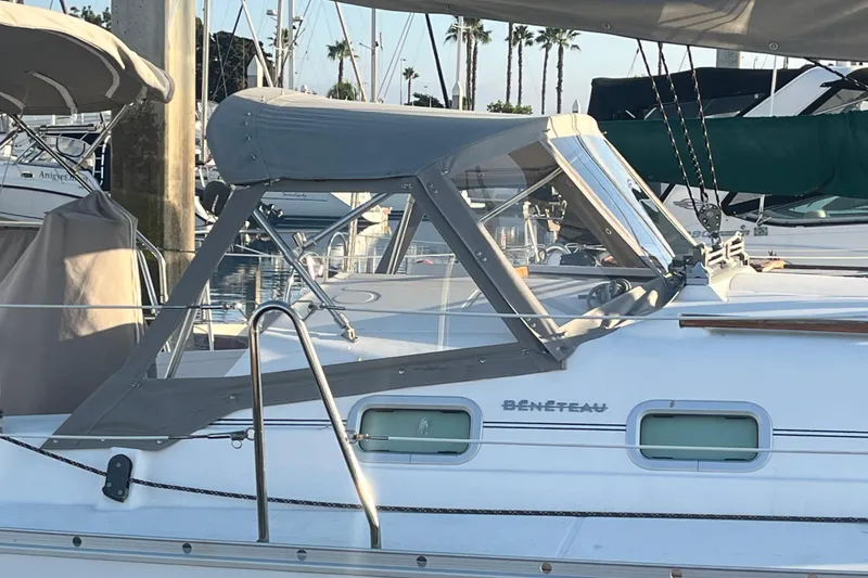 Slide: The Image of 2005 Beneteau 323 sailboat with gray canopy docked at marina. - 46