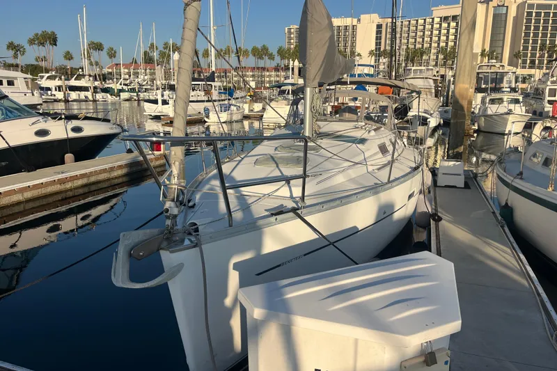 Slide: The Image of 2005 Beneteau 323 sailboat docked in a marina, surrounded by other boats. - 47
